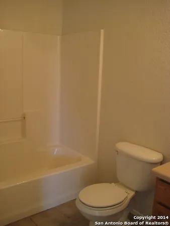 a white toilet sitting next to a bath tub and a shower