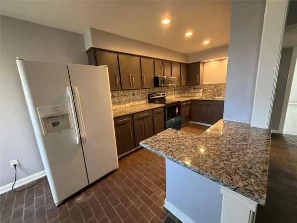 a kitchen with stainless steel appliances granite countertop a refrigerator and a sink
