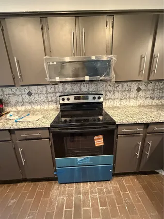 a kitchen with granite countertop a stove and a sink
