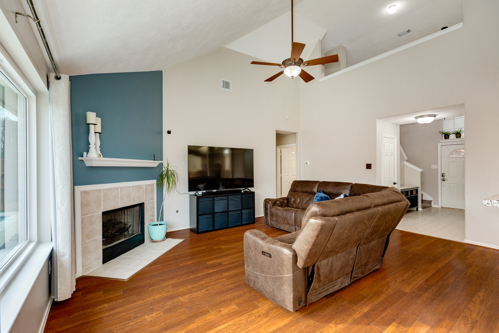 4113 Merlet Drive Pearland, TX 77584 - Photo 9 of 36 This view highlights the seamless transition from the front entrance to the inviting family room. The open ceiling allows for a bright and airy connection to the upstairs, while the laundry room is conveniently located just beyond, providing easy access to the garage.