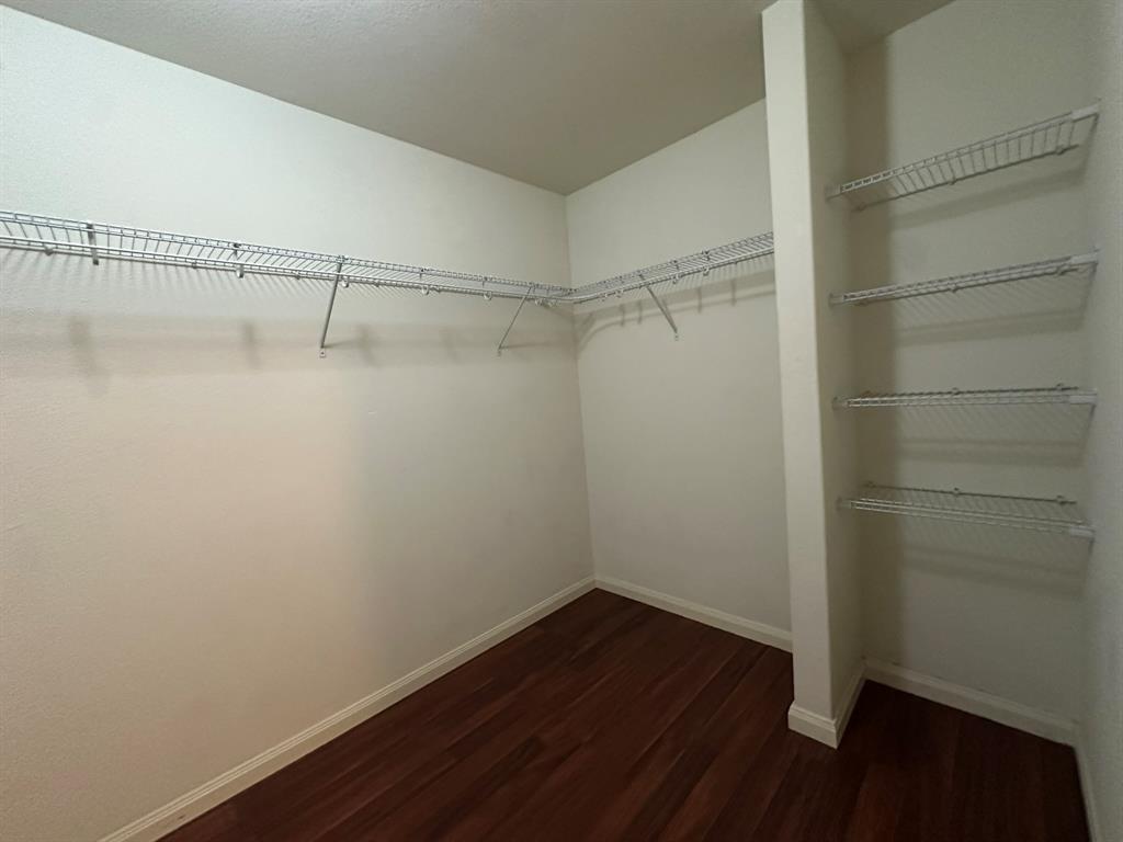 1818 Clegg Street Howe, TX 75459 - Photo 18 of 34 Walk-in closet featuring wood-finish flooring, white walls, and built-in wire shelving
