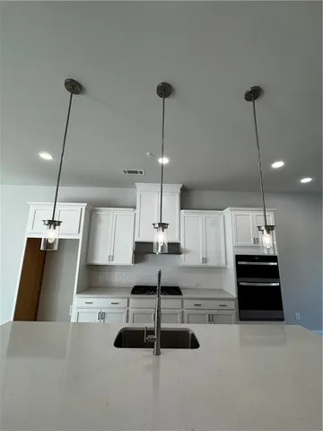 a view of a room with kitchen island stainless steel appliances and living room view