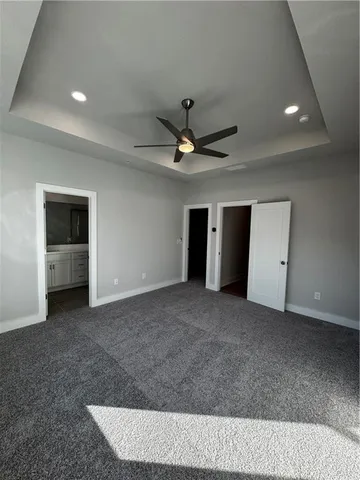 a living room with a ceiling fan and a rug