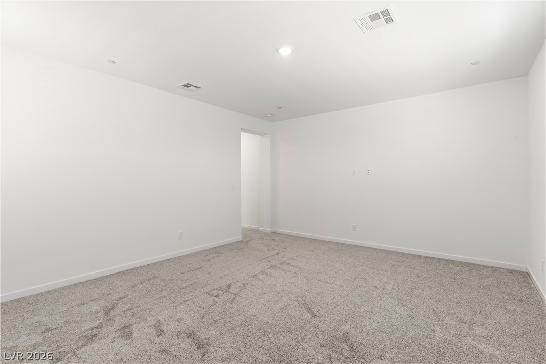 320 Isla Enclave Way Henderson, NV 89011 - Photo 21 of 49 An airy room offers a versatile canvas for living, illuminated by recessed lighting and featuring plush carpeting.