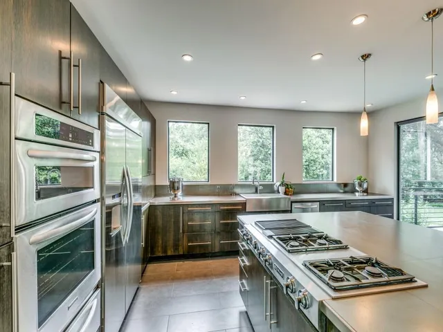 a kitchen with stainless steel appliances granite countertop a stove a sink and a refrigerator