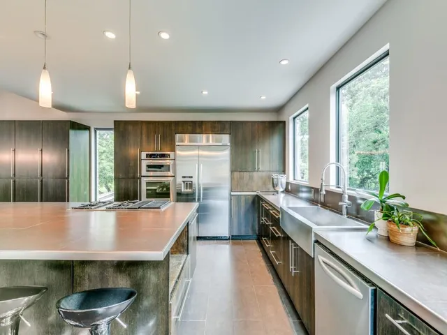 a kitchen with stainless steel appliances a sink a stove and a wooden floors