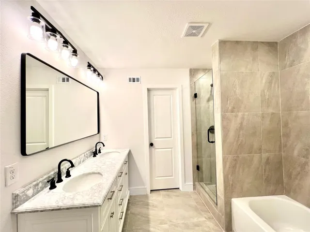 a bathroom with a tub sink and mirror