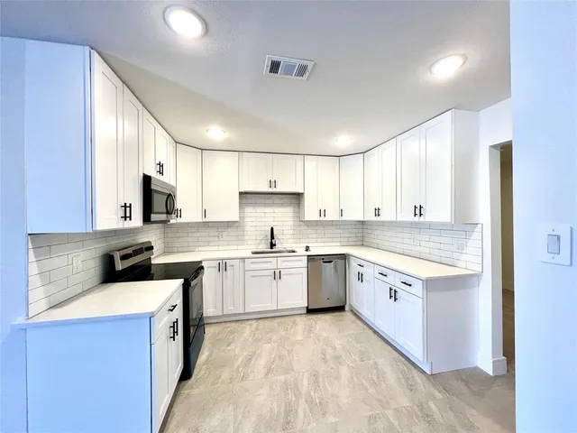 a kitchen with a sink stove top oven and refrigerator