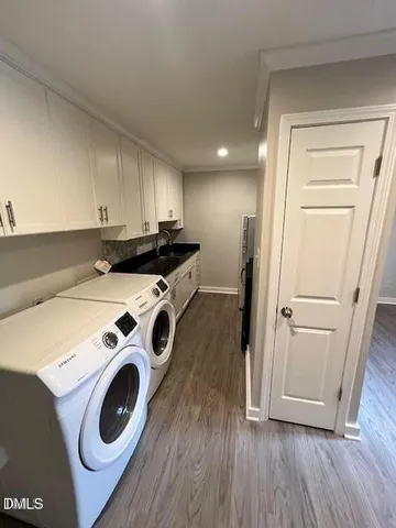 a view of washer and dryer with wooden floor