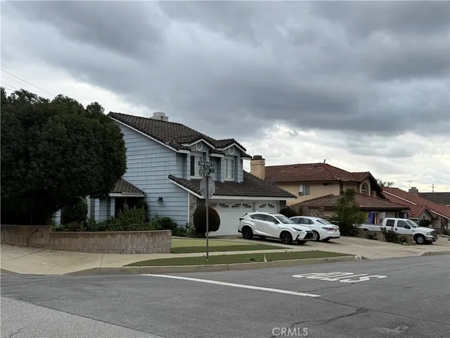 a front view of a house with a garden and parking space