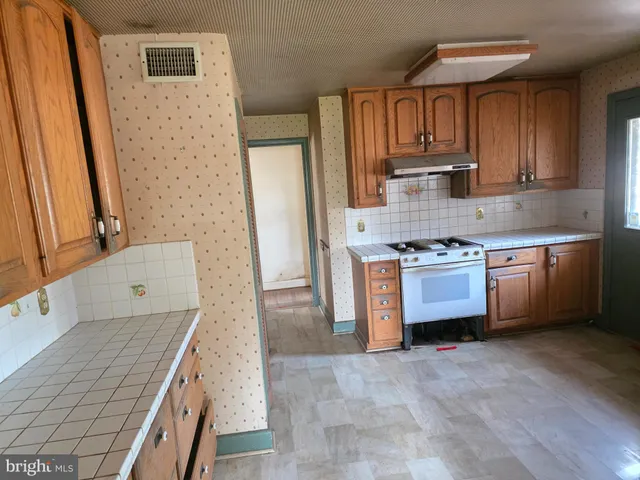 a kitchen with stainless steel appliances a stove a sink and a microwave