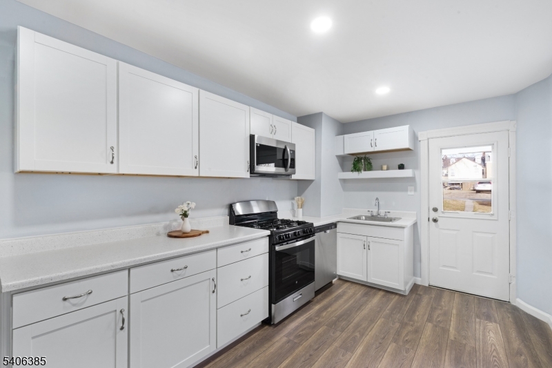 313 Mercer Street Phillipsburg, NJ 08865 - Photo 9 of 29 a kitchen with cabinets stainless steel appliances a sink and wooden floor
