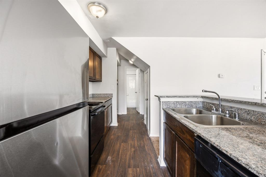 9837 Walnut Street, Unit S203 Dallas, TX 75243 - Photo 9 of 26 The kitchen features a stainless steel refrigerator, dark wood cabinetry, granite countertops, and a double basin sink