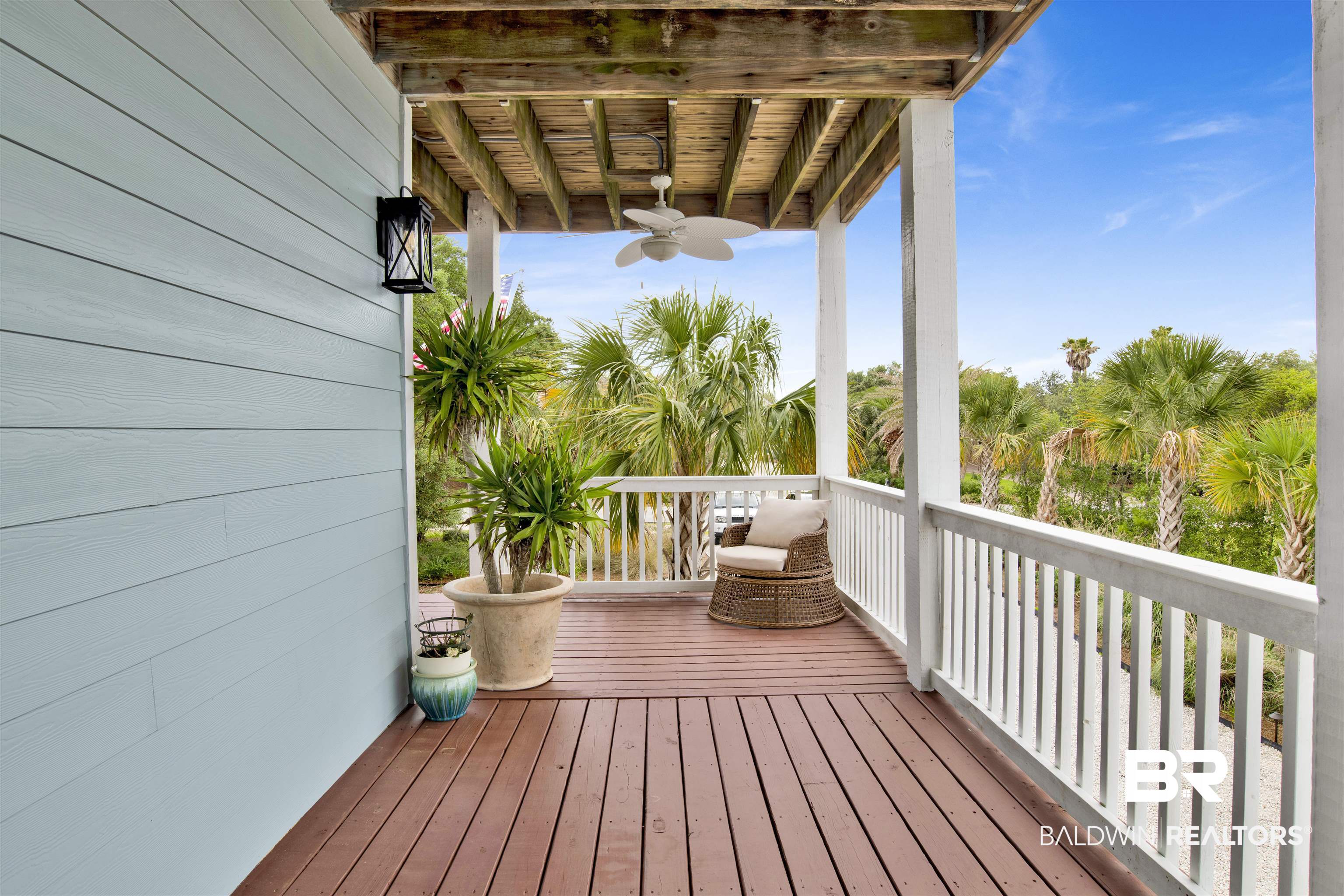 30351 River Road Orange Beach, AL 36561 - Photo 31 of 44 Expansive outdoor deck featuring wood-finish flooring, white railing, blue siding, a dark exterior light fixture, and a ceiling fan