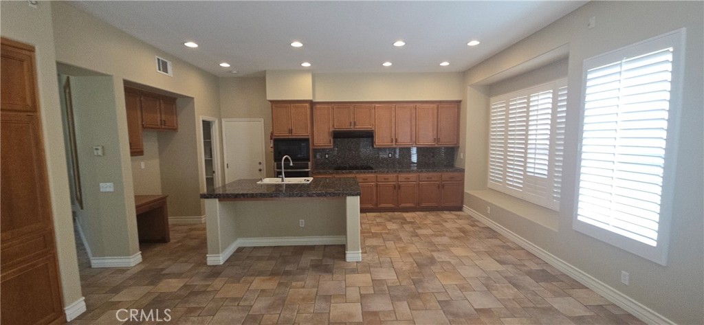 20 Berlamo Rancho Santa Margarita, CA 92688 - Photo 5 of 34 a view of a kitchen with kitchen island granite countertop a refrigerator a sink a counter top space and cabinets