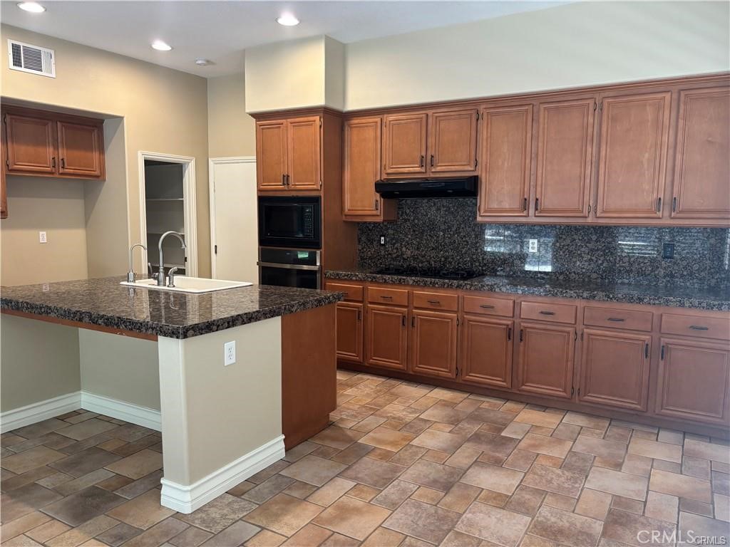 20 Berlamo Rancho Santa Margarita, CA 92688 - Photo 6 of 34 a kitchen with stainless steel appliances granite countertop a stove a sink and a microwave