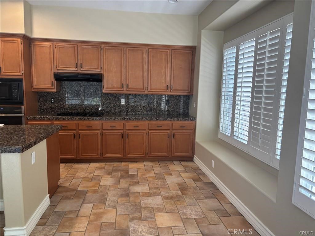 20 Berlamo Rancho Santa Margarita, CA 92688 - Photo 8 of 34 a kitchen with stainless steel appliances granite countertop a stove a sink and a microwave