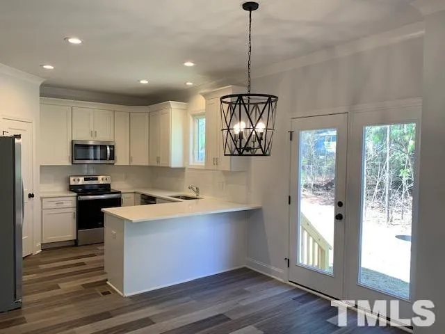 a kitchen with stainless steel appliances kitchen island a stove a refrigerator and a sink
