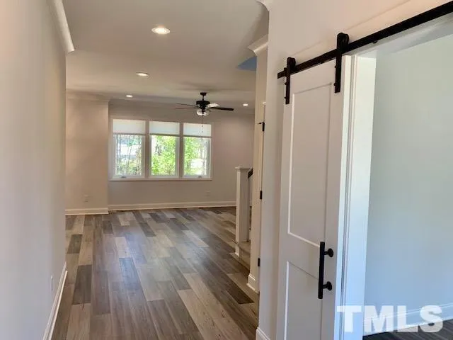 a view of hallway with a window and wooden floor