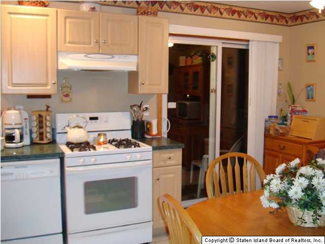 414 Raritan Avenue Staten Island, NY 10305 - Photo 2 of 3 a kitchen with appliances cabinets and a table