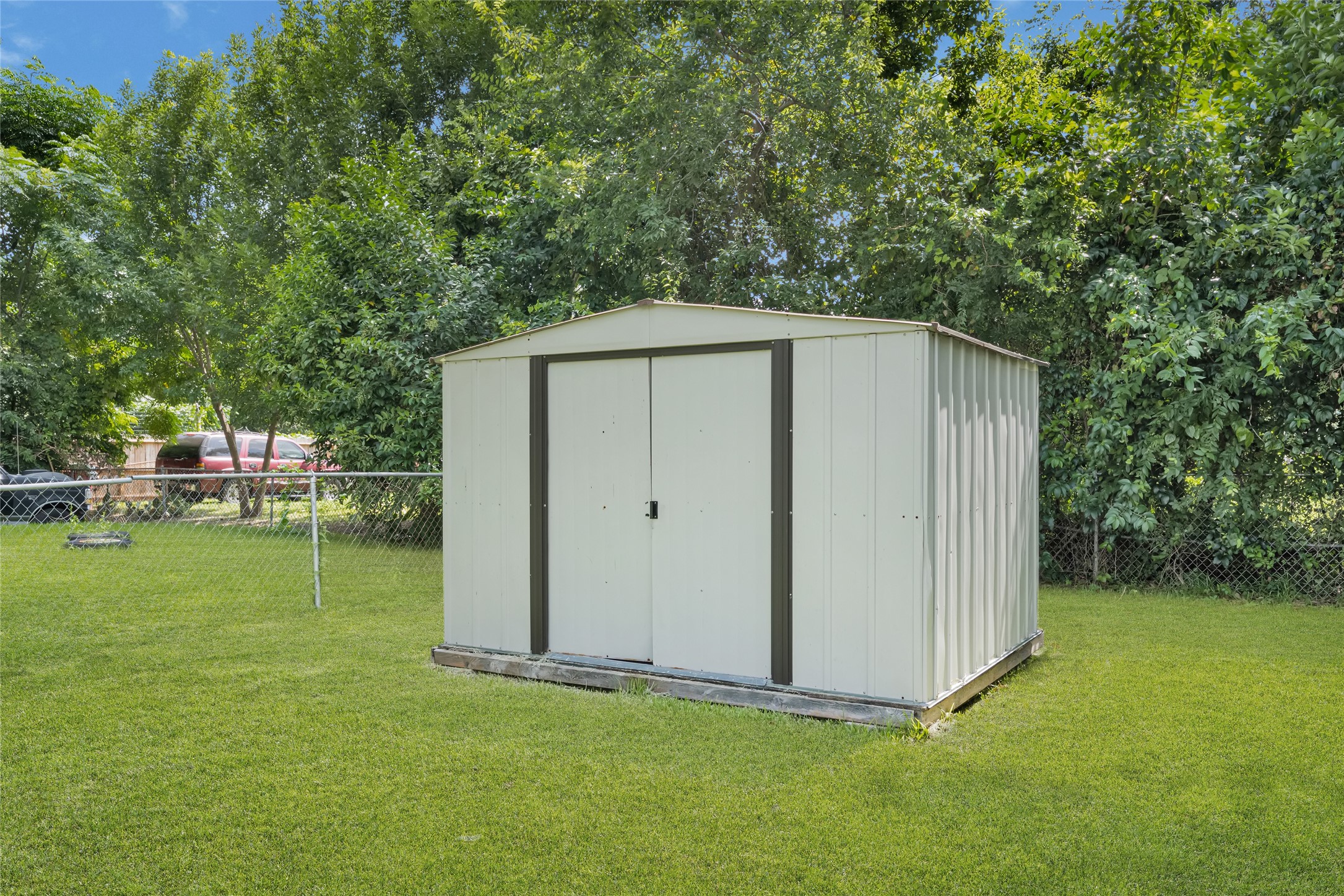 9210 Compton Street Houston, TX 77016 - Photo 45 of 50 A spacious backyard featuring a sturdy metal storage shed, perfect for organizing tools and outdoor equipment.