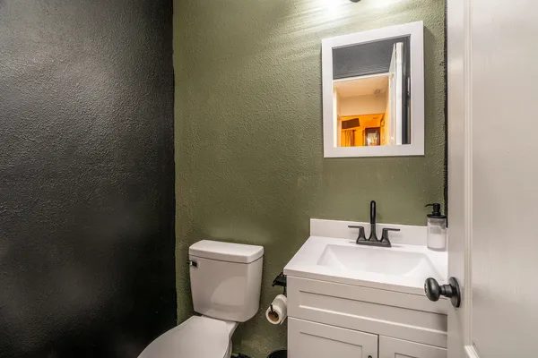 a bathroom with a toilet sink and mirror