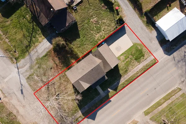 a aerial view of a house with a yard and large tree