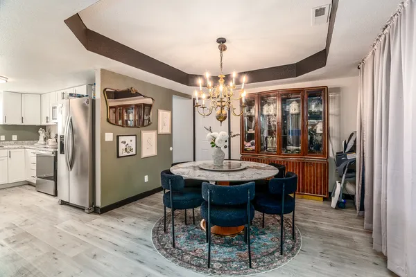 a view of a dining room with furniture and chandelier