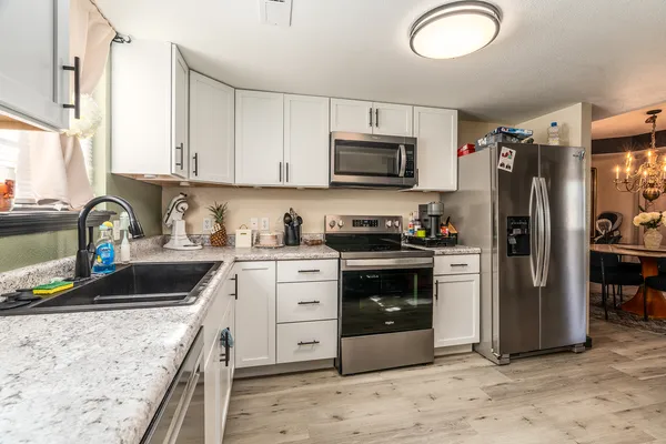 a kitchen with stainless steel appliances granite countertop a refrigerator stove and sink