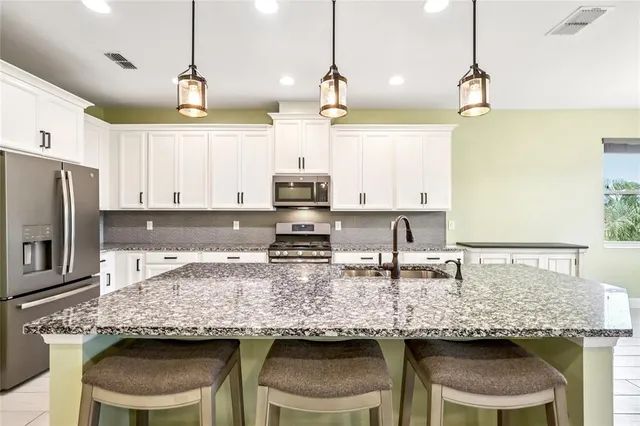 a kitchen with granite countertop sink table and chairs