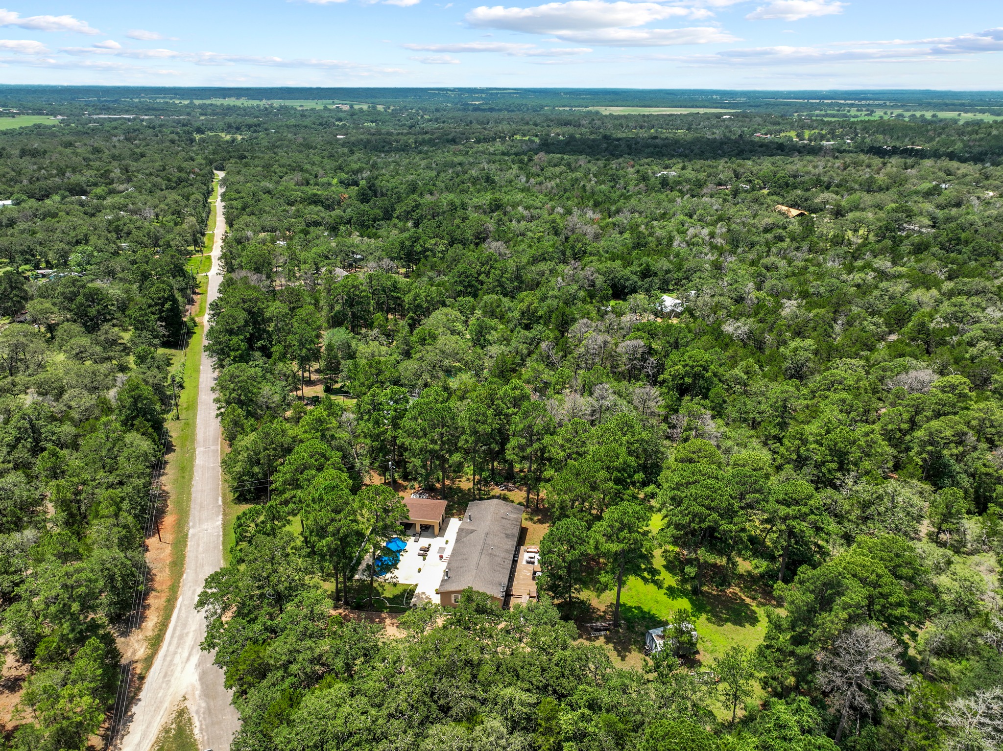 438 Kellar Road Smithville, TX 78957 - Photo 30 of 30 An aerial perspective reveals a secluded estate nestled within a dense, verdant forest, featuring a private swimming area.