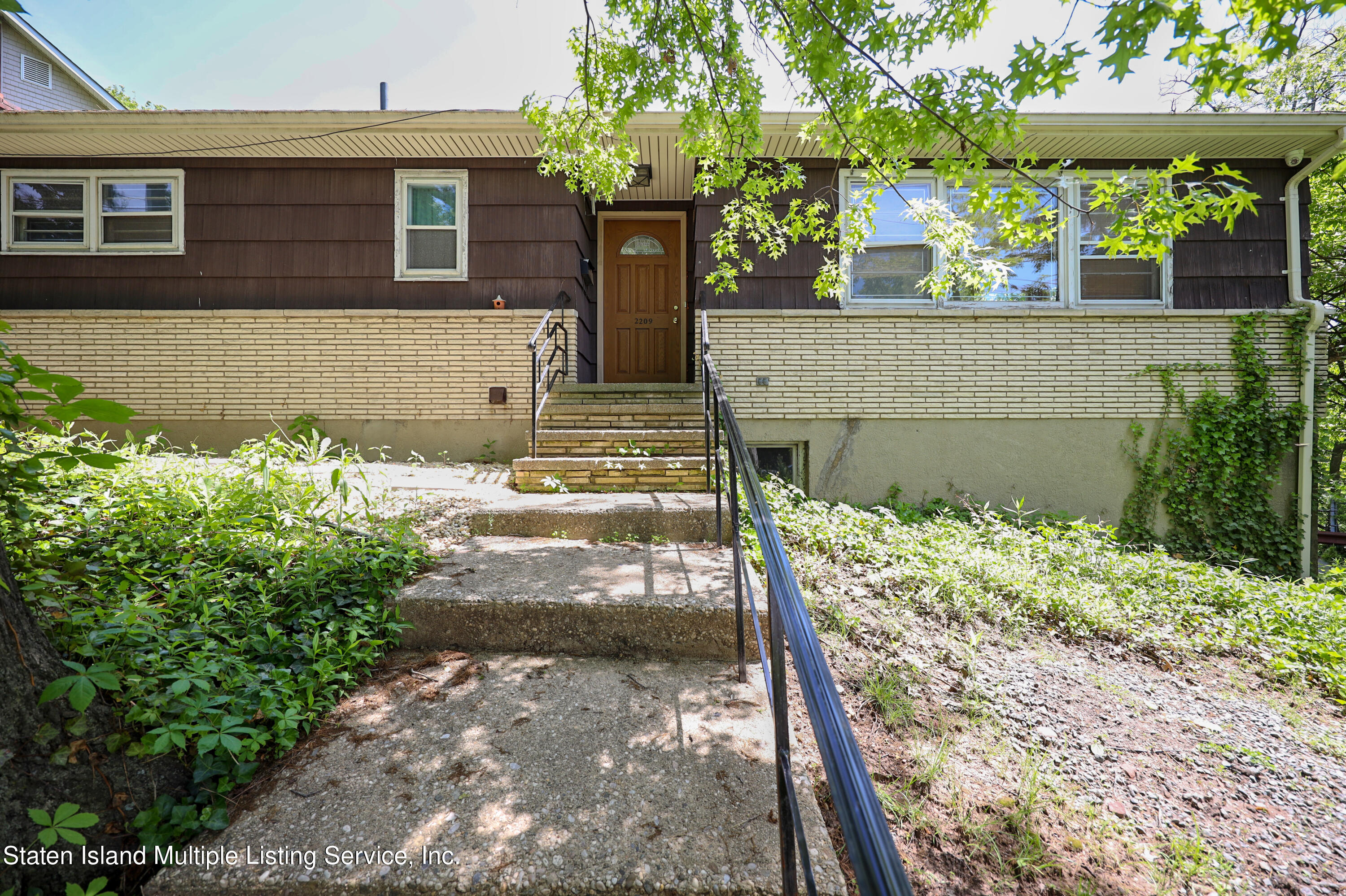 2209 Clove Road Staten Island, NY 10305 - Photo 1 of 38 a front view of a house with garden