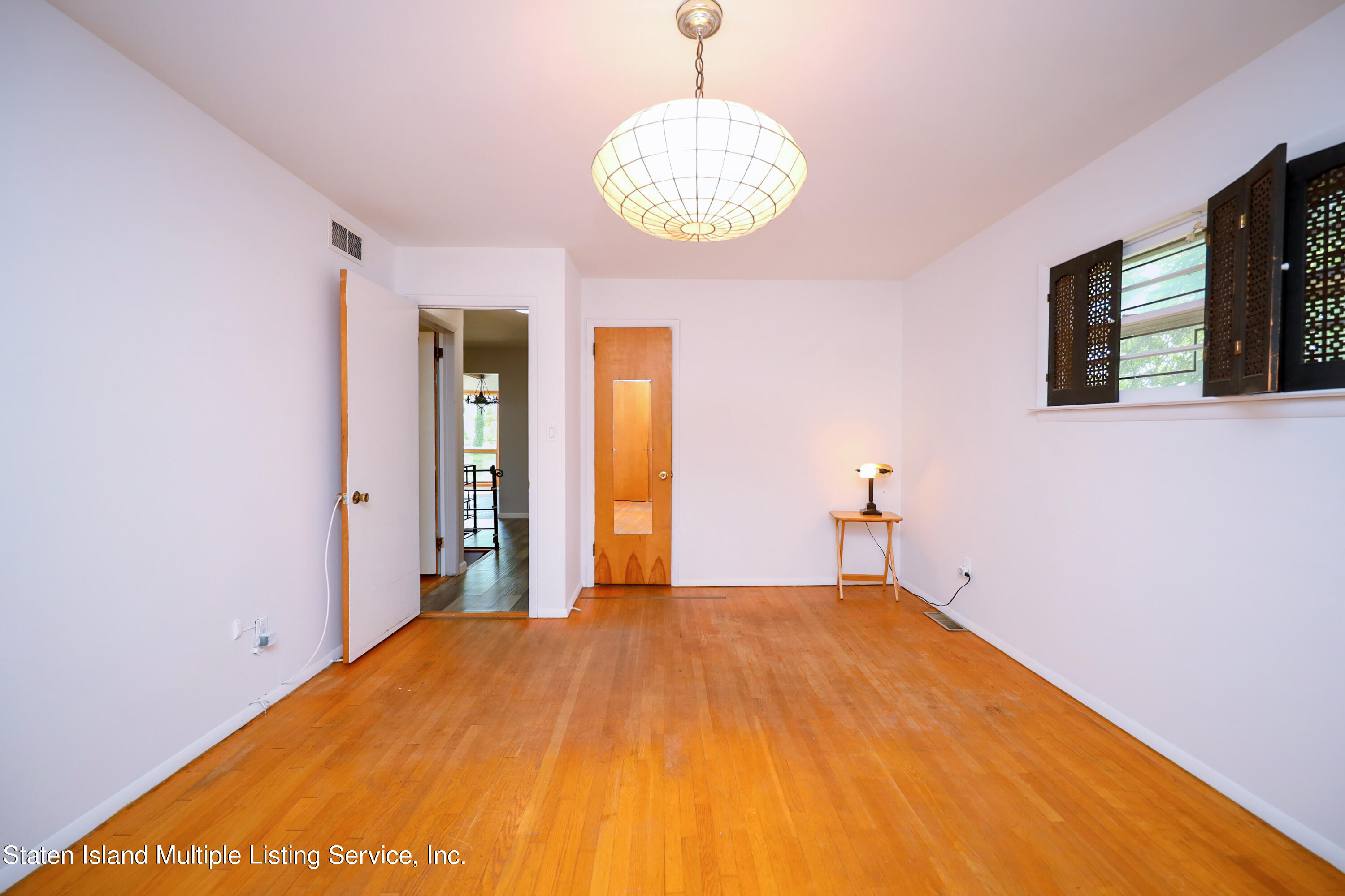 2209 Clove Road Staten Island, NY 10305 - Photo 11 of 38 a bedroom with a bed and a chandelier