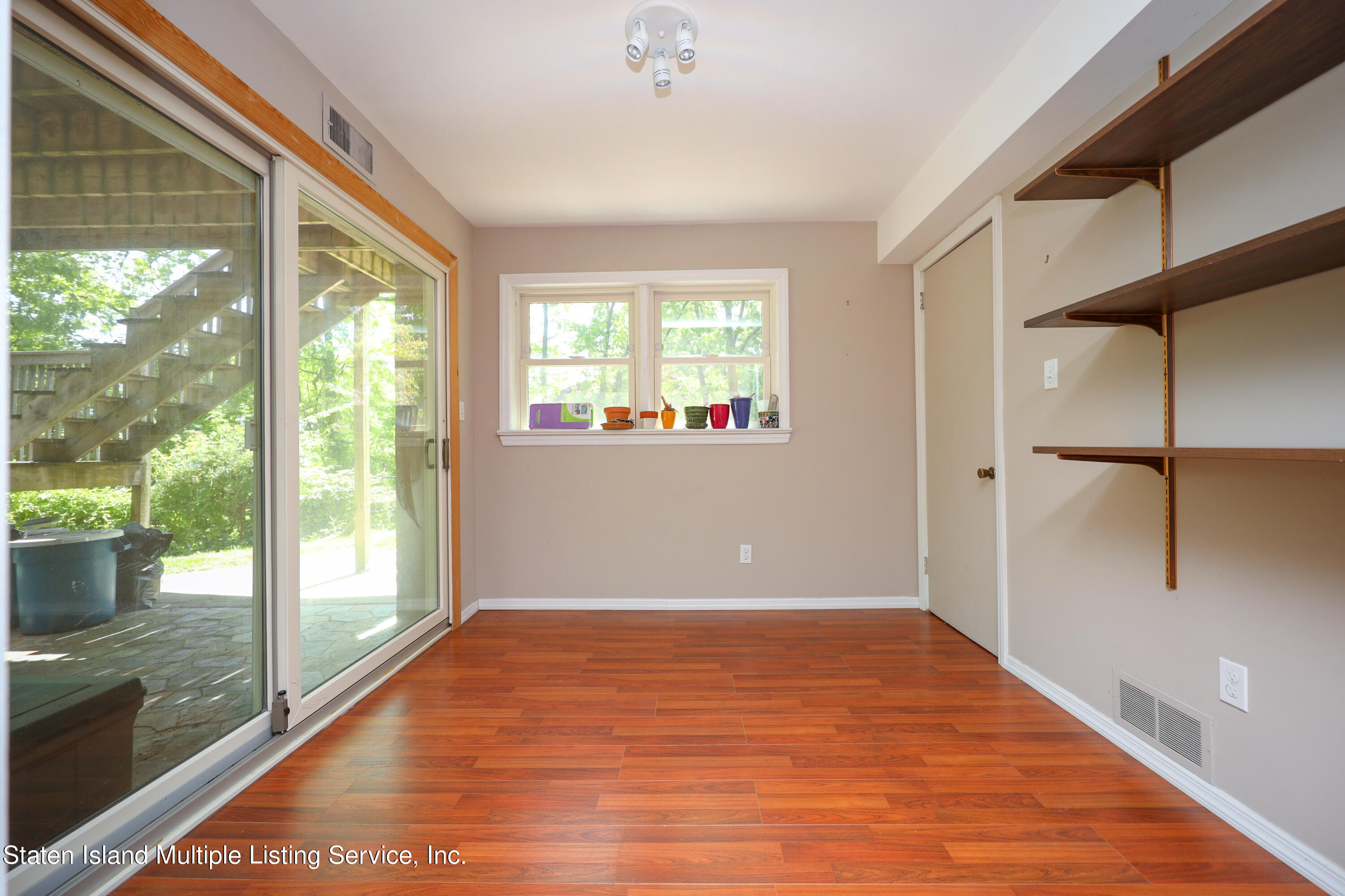 2209 Clove Road Staten Island, NY 10305 - Photo 16 of 38 a view of an empty room with wooden floor and a window