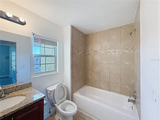 a bathroom with a granite countertop toilet a sink and bathtub