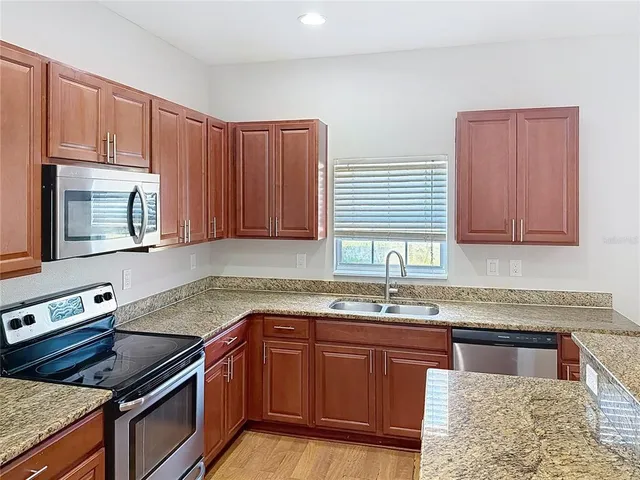a kitchen with stainless steel appliances granite countertop a sink stove and cabinets