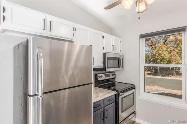 a kitchen with stainless steel appliances granite countertop a refrigerator a stove and a sink