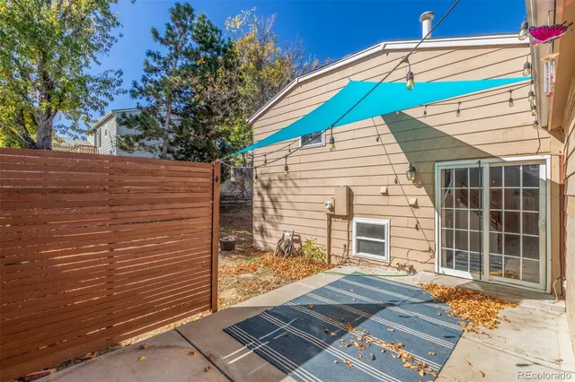 a view of a backyard with wooden fence and a large tree