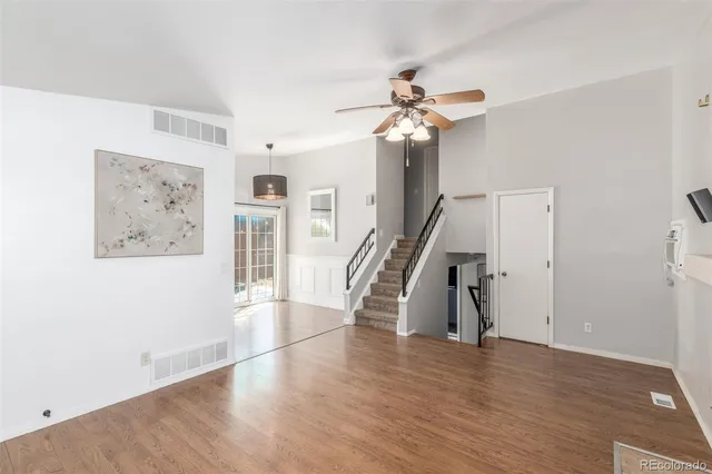a view of a hallway with wooden floor and staircase