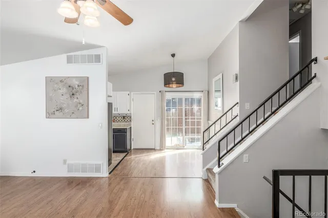 a view of a livingroom with wooden floor and stairs