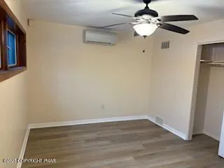 a view of a room with wooden floor and ceiling fan