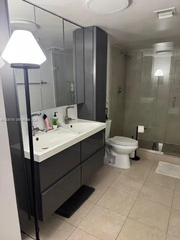 a bathroom with a double vanity sink toilet and shower