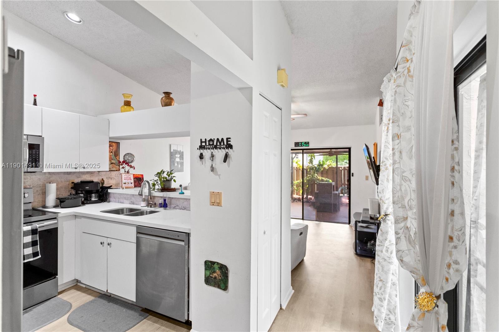 17320 Northwest 66th Place Hialeah, FL 33015 - Photo 17 of 47 a kitchen with a sink dishwasher and white cabinets with wooden floor