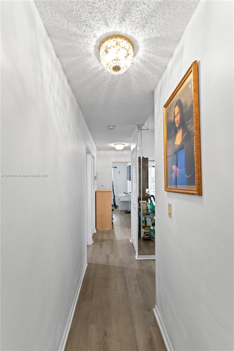 17320 Northwest 66th Place Hialeah, FL 33015 - Photo 21 of 47 a view of a hallway with wooden floor and workspace