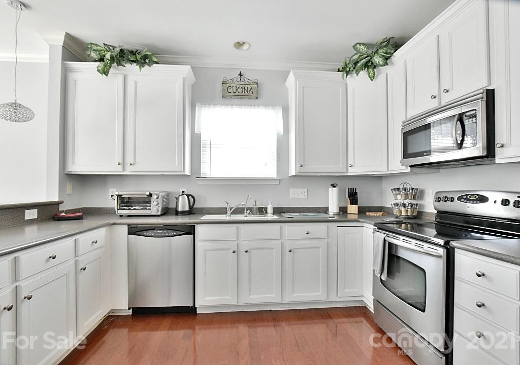 265 Sand Paver Way Fort Mill, SC 29708 - Photo 14 of 29 a kitchen with granite countertop cabinets stainless steel appliances and wooden floor