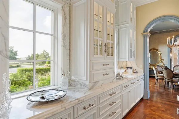 a bathroom with a granite countertop sink and a large mirror next to a window