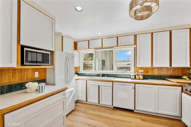 a large white kitchen with a large window