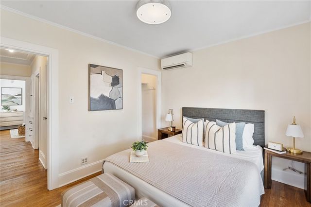 a bedroom with a bed and wooden floor