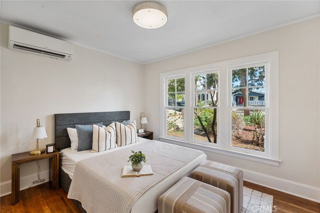 a bedroom with a bed and wooden floor