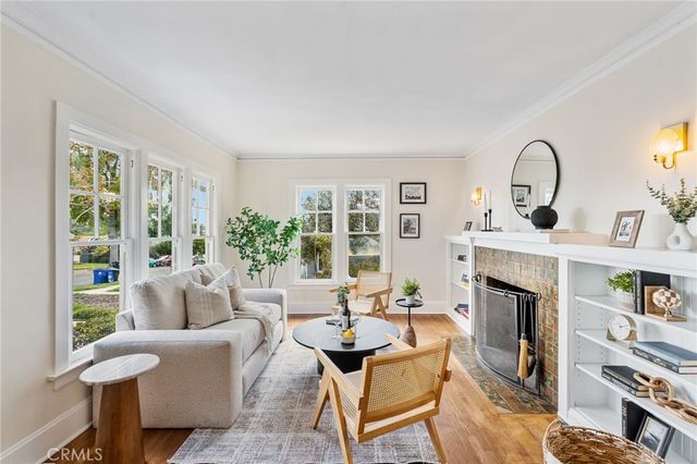 a living room with furniture a fireplace and a large window